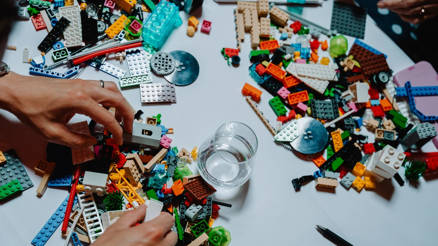 Hands building LEGO models during a Serious Play workshop